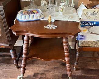 Glass claw foot table in dining room - items include Fostoria square cake plate, candles, & collectibles  