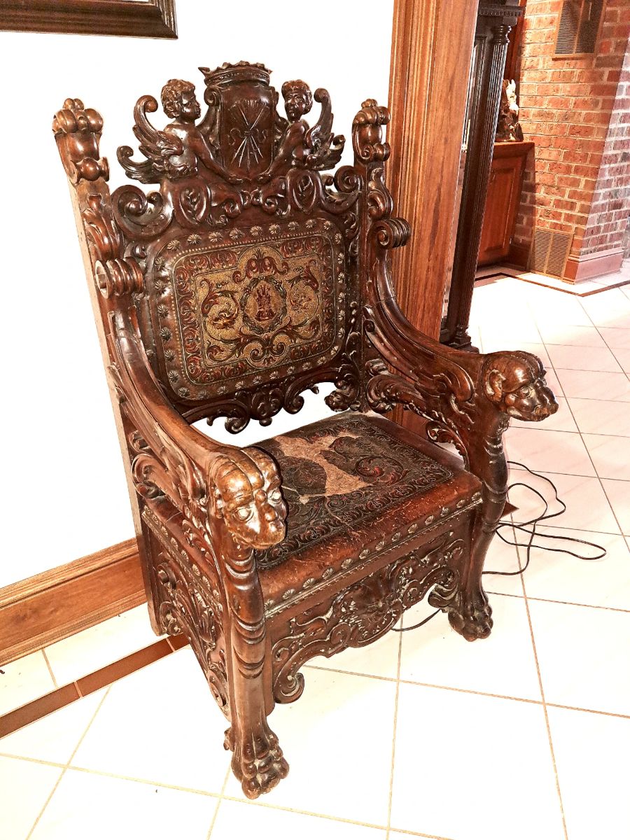 19th century heavily carved throne chair with chased leather back and seat.