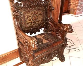 19th century heavily carved throne chair with chased leather back and seat.