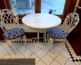Round marble top table with two chairs.