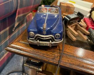 Vintage Arnold Tin Toy remote controlled sedar convertible with man driver and woman passenger. 
