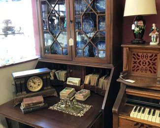 Beautiful Maddox secretary with drop front desk/cubbies and secrete compartments. Fret work on Curio. Chicago Kimball Pump Organ, Blue and White Plates, Vintage Mantel Clock.