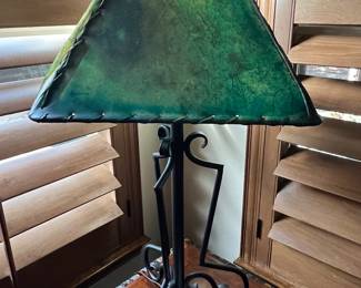Wrought iron lamp with stitched green leather lamp shade.
