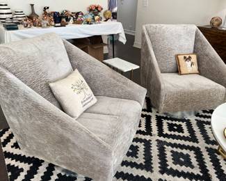 Two of these gray velvet swivel chairs
