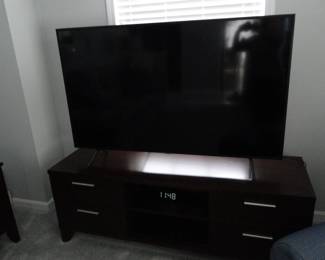 Thats better.  Large flat screen TV, and very nice TV stand, that has a bit of a nod to Mid Century Modern