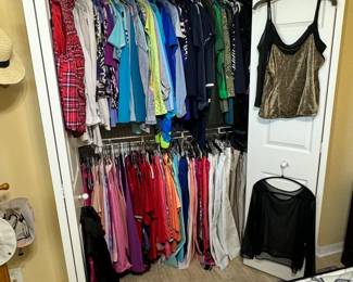 Variety of women's shorts, pants, leggings, shirts, shoes. Clothes are size Large -ish.