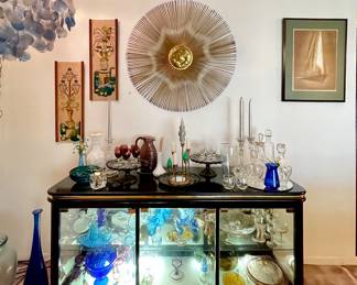Broyhill Lighted credenza, Black Lacquer Chinoiserie Style 
Brutalist Sunburst Wall Sculpture, Hand signed by the artist, Devall, for Casa Devall
Mid Century Capiz Shell and Brass Chandelier with Blue tinting 
Gravel Art Fountain/Lanterns pair
Mid Century Sailboat signed numbered 