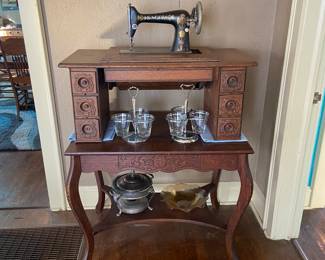 Antique Singer sewing machine table (has no cast iron legs) atop a side table