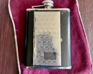 Stainless steel flask.  Front cover opens to reveal cigarette holder.