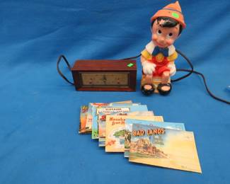 Lot 455. Pinocchio bank, souvenir postcards, and a vintage working Philco clock