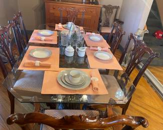 a very nice glass dining table with beveled edges. There are 8 antique Chippendale chairs includes. 