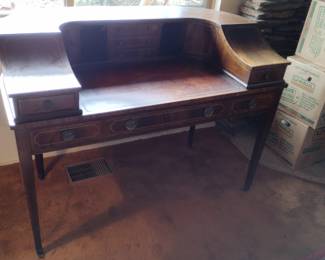 Antique 19th-century European “bureau à gradin”-style writing desk with many small drawers and compartments along the back and sides.

Condition is good, but it does have some nicks, chips (see photo), and scratches, and the finish on the top is peeling a little (see photo).

Front drawer has lock and key. Inlays on drawers. Legs have small, elegant wheels. Gold-embellished writing surface. Appears to be entirely original.

50" W x 28" D x 37" H