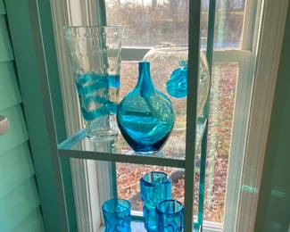 Blue wrought iron shelf with a variety of blue glass