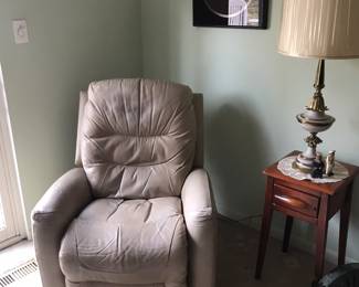 Tan/beige recliner below a Thrasher print, Neat maple table with lamp!
