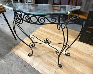 A beautiful wrought iron entry hall table with a glass top.