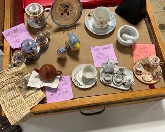 mini tea sets including a Peter Rabbit set, small mortar & pestle,  tea kettle more sal &peppers... and a cowbell in the upper right corner.