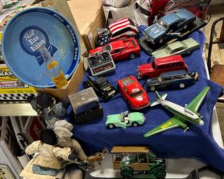 NOTE: please read the complete description for this picture - the red Mercedes Benz (in the middle facing away) - this car is a 9 inch  Mercedes-Benz with the exposed see-through hood to view the engine and all 4 hubcaps are still intact!!! We have a wide selection of older & newer vehicles, also pictured - PBR beer tray, ethnic dolls, FARMERS & Merchants Bank - Jefferson WI, w/ original box, John Deere Airplane Bank.  AND THE LARGE BLACK ITEM ON THE BOTTOM OF THE PIC is... 
Dr. Reinhardt’s HOG HOLDER/PIG MOVER!!! It can hook on different size of snouts to move the hog/pig around! (Every home should have one!!)