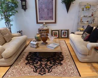 Pair of loveseats, travertine coffee table, area rug