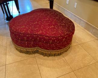 Nice, large red ottoman with fringe on bottom - next to Piano