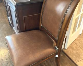 One of two nailhead trimmed leather chairs