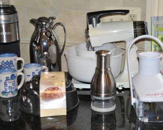 A Fantastic Selection of Coffee & Baking Essentials Including a Keurig Coffee Maker, a Vintage Sunbeam Mixmaster Mixer and M.A Hadley Signed Hand Painted Ceramic Coffee Mugs.