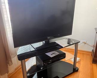 LG tv and smoking black glass tv stand