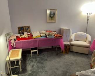 In this photo are several items of interest:  the floor lamp, the white chair, a wicker bench, the framed art on the wall, and more.