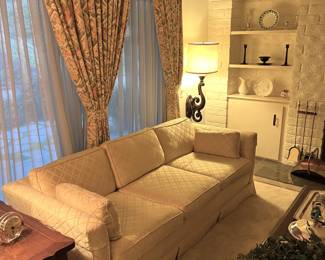 Another look at the sofa and a corner of both the side table and the coffee table.  A few decorative items are visible on the background shelves.