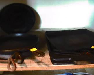 Numerous cast iron cooking vessels.