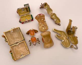 Interior view of enamel and rhinestone trinket boxes, featuring a Chinese dragon, a train, a giraffe, a lion, a fly, and a flower basket