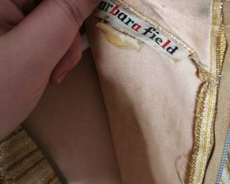 Tag detail of Barbara Field sleeveless gold lame a-line dress with french dart fitting details, zip back closure