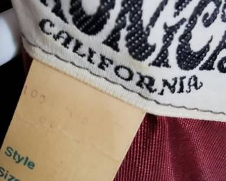 Size tag detail of 1960s Sandi Monica California brown swing dress with a zip back, a funnel neck, and fur sleeve cuffs, Size 10