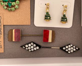 Two vintage stick pins, a brass stick pin with red, white, and brass  enamel ends and a black enamel and rhinestone stick pin