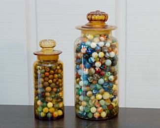 Jars of antique marbles including old clay marbles