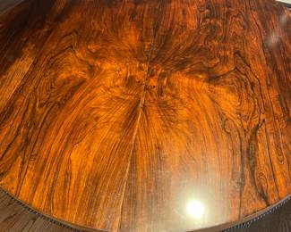 English Tilt-Top Table, circa 1890's.  Rosewood veneered round top (large) with conical central leg on tripod. Decorated with detailed various cutting and nailheads. Carried by  claw feet on wheels. Very nice wax patina.
Original hinge and closing fitting for tilting the top. 
53.5" D x 29.5" H. 