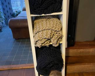 Assorted chunky Pottery Barn blankets and IKEA shelving 