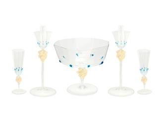 159
Mid-20th century
A Set Of Salviati Murano Glass Stemware
Each appears unmarked
Each octagonal rimmed piece with applied teardrop trails of blue at corners, above a twisted knop imbued with gold flecks and a round foot, consisting a footed compote bowl (8.75" H x 9.75" Dia.), a pair of candleholders (12.625" H x 5.25" Dia.), and nine champagne flutes (8.25" H x 2.875" Dia.), 12 pieces
Estimate: $2,000 - $3,000
