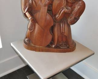 "Beggars" Wood Carving by Karoly Fulup on a modern leather-top side table