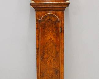An early 18th century English grandfather clock by "John Austin, London" (worked 1702-1725).  8-day weight driven time and strike movement with arched Brass dial and Silvered chapter ring with Roman numerals, cast Brass spandrels and lower date aperture.  Burl Walnut case with feather inlaid detail and edge banding features a hood with a flat molded top, over arched filigree panels and a glass dial door flanked by turned columns over a long waist door with arched top and a lower base with molded plinth.  Older refinishing with some restoration, minor veneer damage, running when cataloged.  88" high.  
