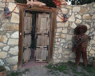 Front Entry Wood & Iron Doors, Metal Musician Statue, Stone Fish Statue