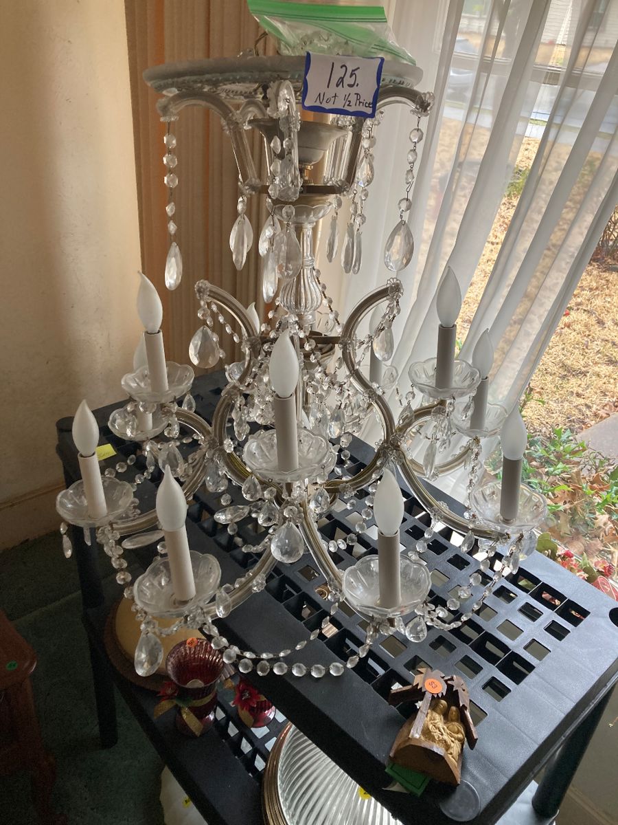 A beautiful crystal chandelier about 27 inches deep and 28 inches wide.