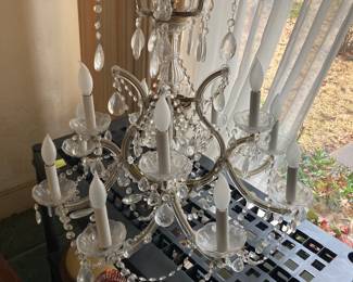 A beautiful crystal chandelier about 27 inches deep and 28 inches wide.