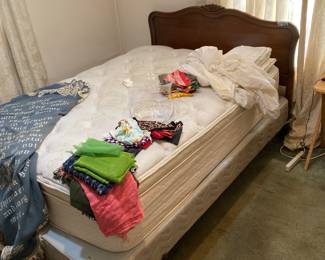 There is a beautiful queen sized antique bed with a headboard, footboard and mattress.