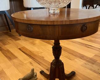 Vintage drum table, stone bird carving on floor at left.