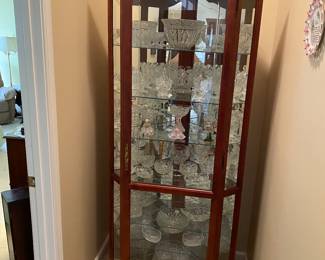 Pretty curio cabinet chock full of lovely crystal and glass.