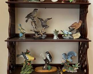 Assorted bird figurines on carved wood shelf