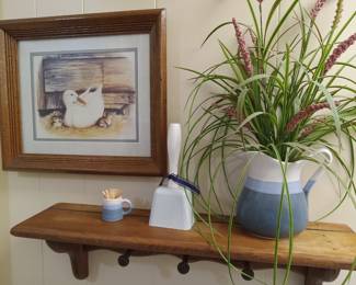 Wood shelf with dowels, floral, bell, framed duck picture. 