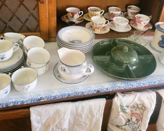 Teacups and saucers, mid-century lazy susan, pitchers, embroidered tea towels