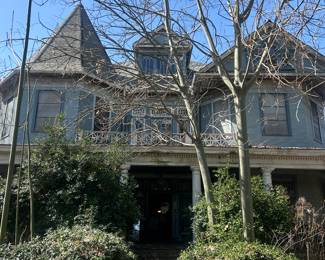 view of house from street with overgrown shrubs
