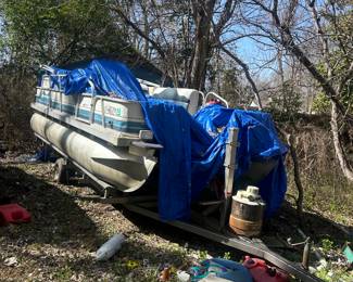 18ft pontoon and trailer in yard with motor